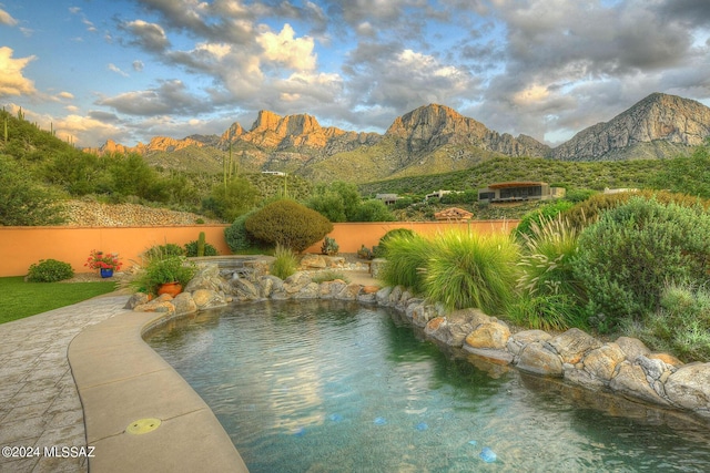 view of swimming pool featuring fence and a mountain view