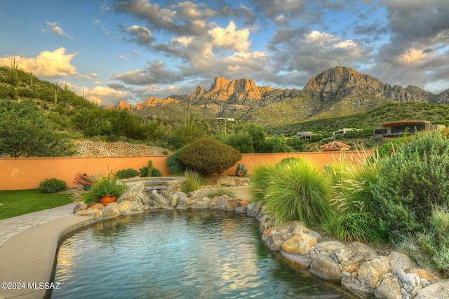 view of swimming pool featuring a mountain view and fence