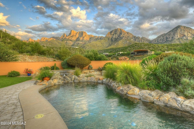 view of swimming pool with a mountain view and fence
