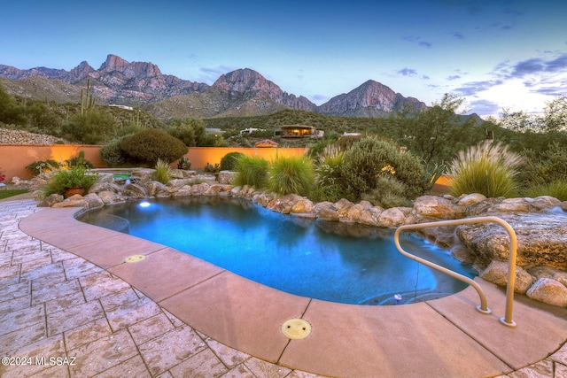 view of swimming pool with a mountain view and a patio area