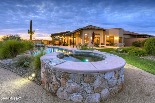 view of swimming pool featuring a patio, fence, and a pool with connected hot tub