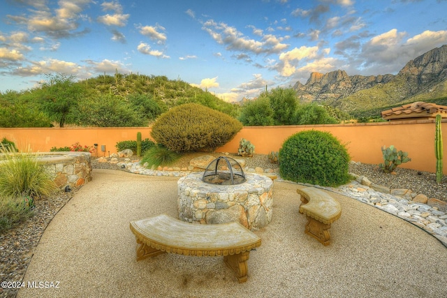 view of yard featuring a fenced backyard, a mountain view, and an outdoor fire pit