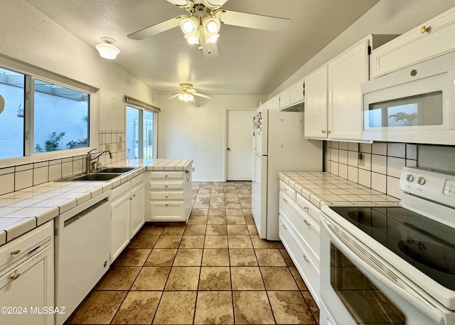 kitchen featuring tile countertops, sink, white cabinets, and white appliances