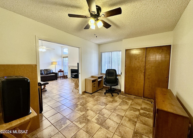 home office with ceiling fan and a textured ceiling