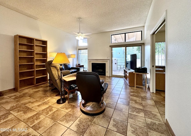 living area with a textured ceiling and ceiling fan