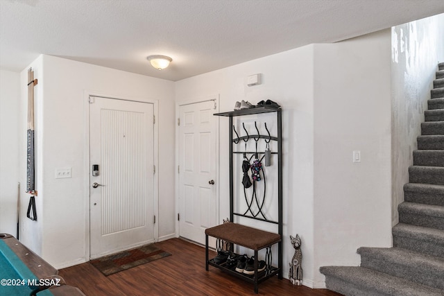 foyer entrance with a textured ceiling and dark hardwood / wood-style flooring