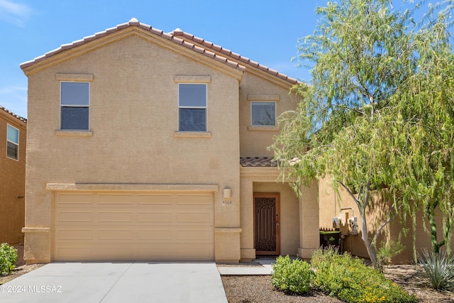 view of front of house featuring a garage, concrete driveway, and stucco siding