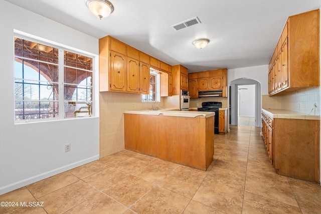 kitchen featuring black range with electric stovetop, kitchen peninsula, white oven, range hood, and sink