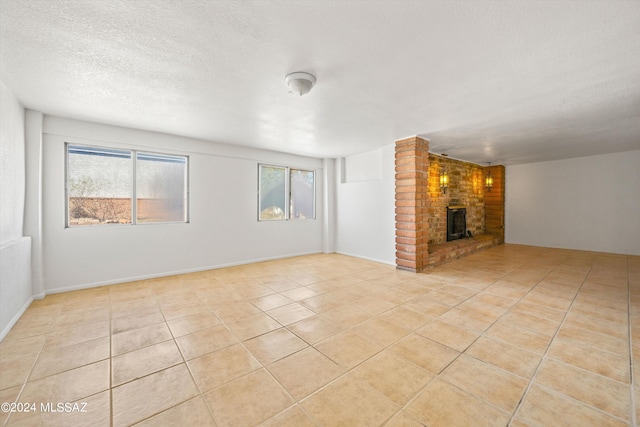 unfurnished living room with a brick fireplace, plenty of natural light, and light tile patterned flooring