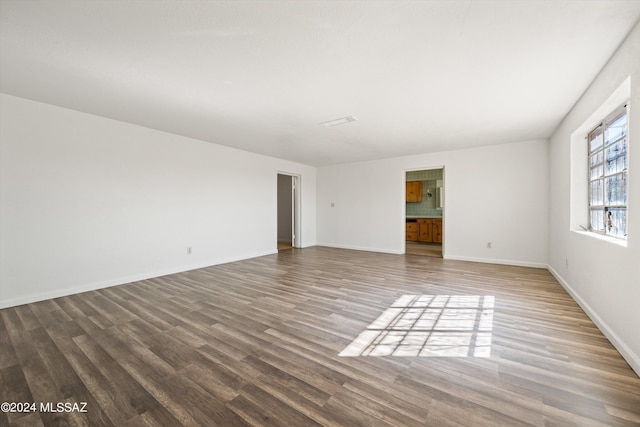 empty room with baseboards and wood finished floors