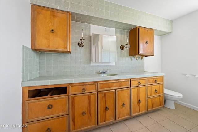 bathroom featuring backsplash, vanity, toilet, and tile patterned floors