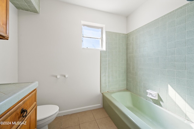 full bathroom with tiled shower / bath combo, vanity, toilet, and tile patterned floors