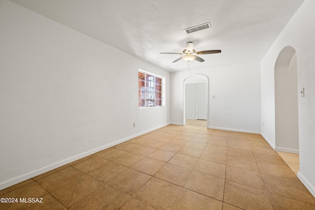 empty room featuring ceiling fan and light tile patterned floors