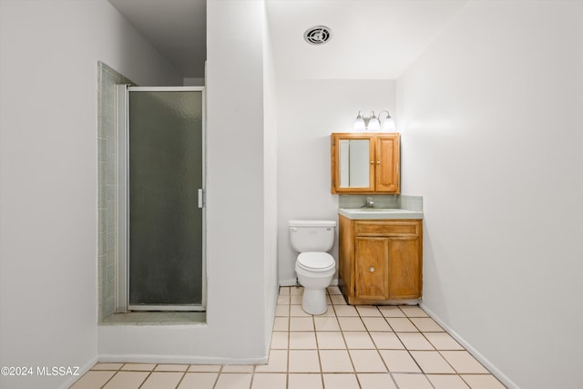 bathroom with vanity, toilet, tile patterned floors, and a shower with shower door