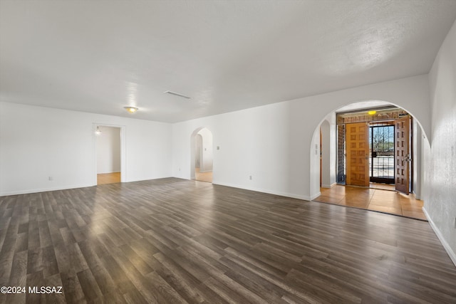 unfurnished living room with dark hardwood / wood-style flooring