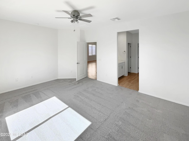 unfurnished bedroom with baseboards, a ceiling fan, visible vents, and light colored carpet