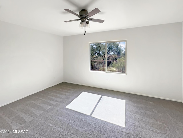 empty room featuring carpet, baseboards, and a ceiling fan