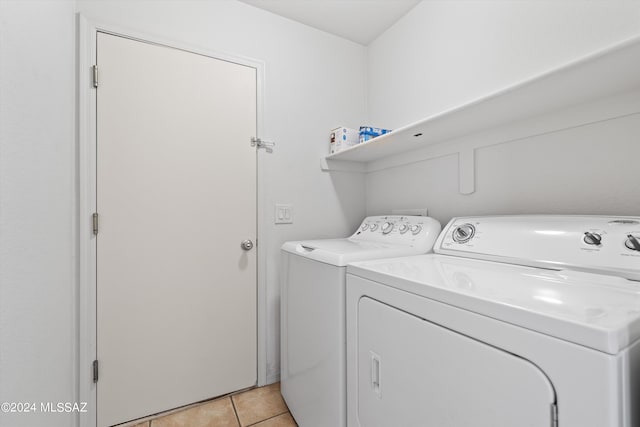 clothes washing area with washer and dryer and light tile patterned floors