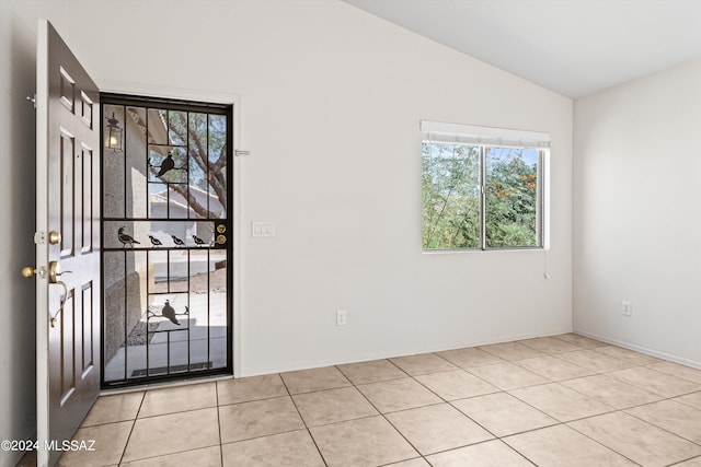 entrance foyer featuring lofted ceiling, plenty of natural light, and light tile patterned flooring