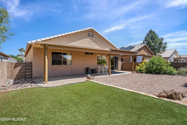 rear view of property with a yard and a patio