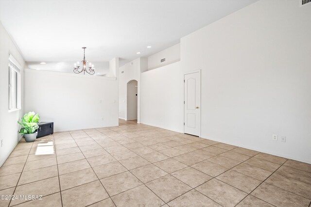 empty room featuring lofted ceiling and light tile patterned floors