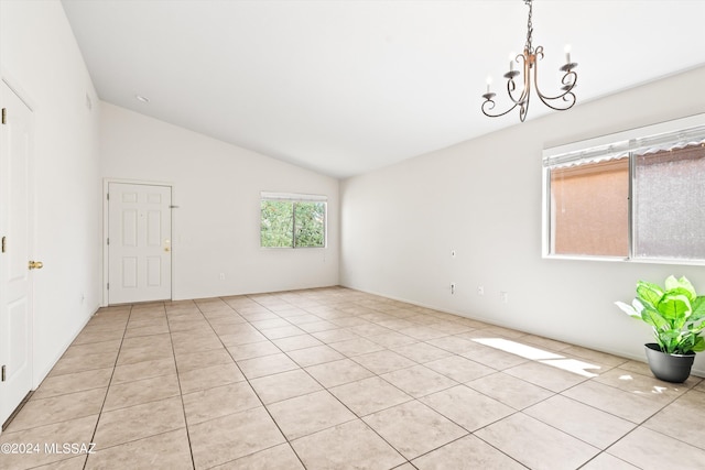 tiled spare room with lofted ceiling and a chandelier