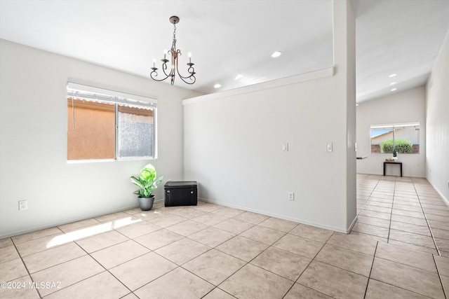 unfurnished room with lofted ceiling, an inviting chandelier, and light tile patterned flooring