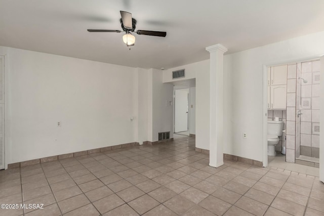 tiled spare room featuring ceiling fan and ornate columns