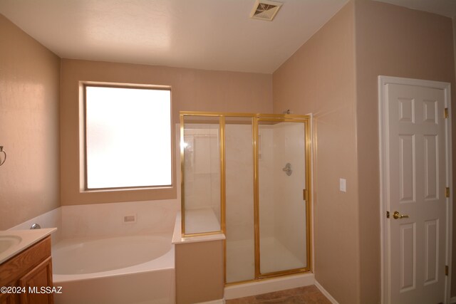 bathroom with vanity and shower with separate bathtub