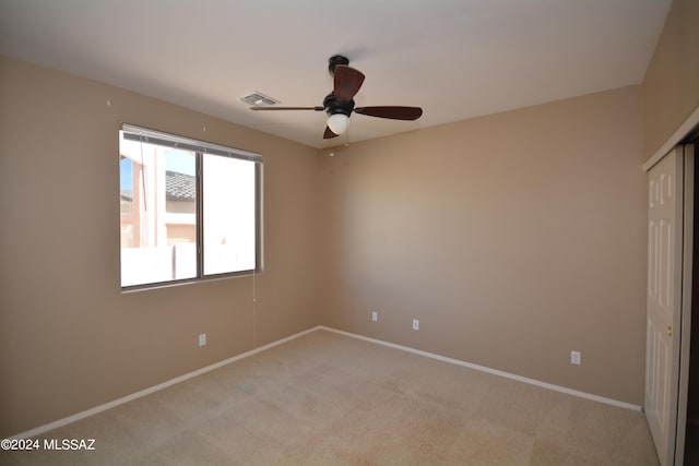 unfurnished bedroom with a closet, ceiling fan, and light carpet