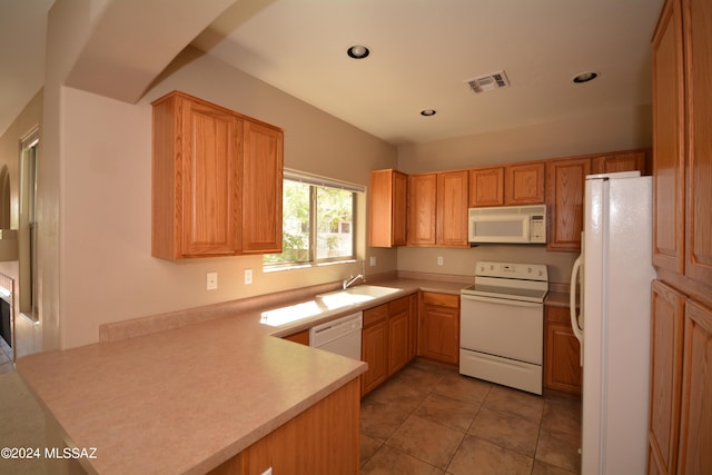 kitchen with white appliances, kitchen peninsula, sink, and light tile patterned flooring