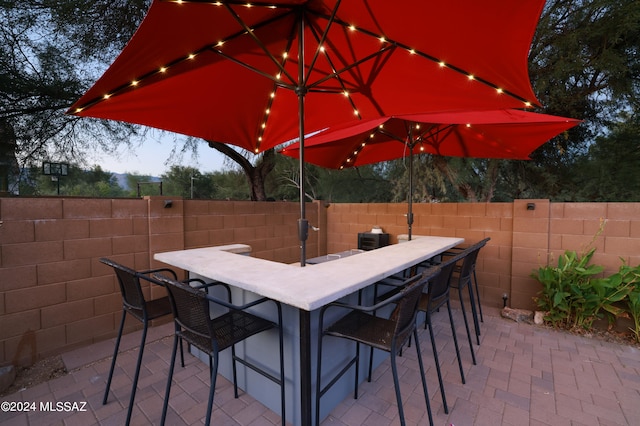 view of patio featuring outdoor dry bar and fence