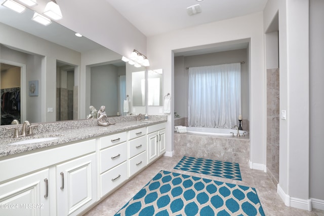 bathroom with vanity and a relaxing tiled tub