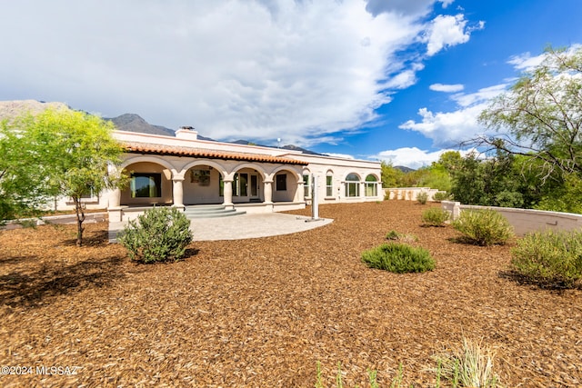 back of property with a patio area and a mountain view