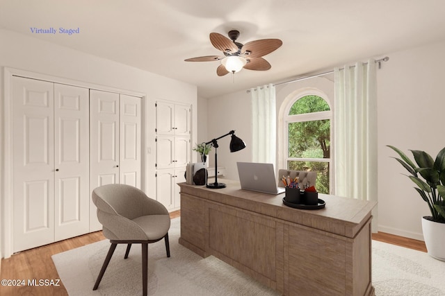 office space with light wood-type flooring, baseboards, and a ceiling fan