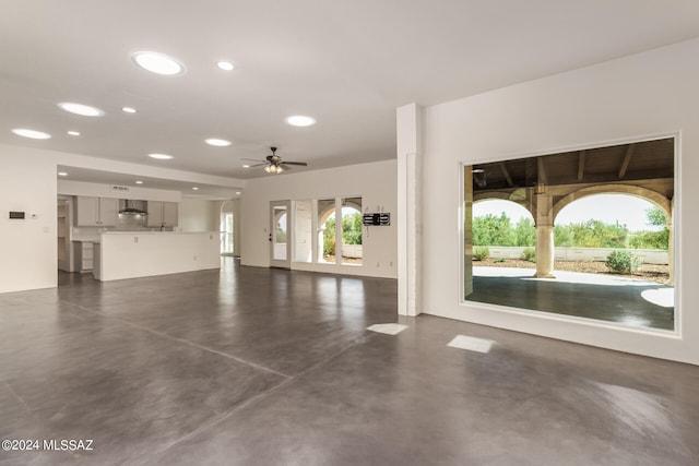 unfurnished living room featuring plenty of natural light and ceiling fan