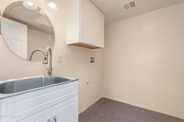 clothes washing area with sink, electric panel, cabinets, and hookup for a washing machine