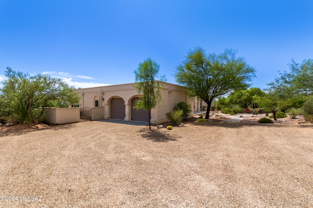 view of front of home featuring a garage and dirt driveway