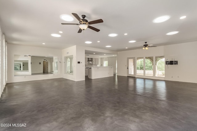 unfurnished living room with a ceiling fan, recessed lighting, and finished concrete flooring