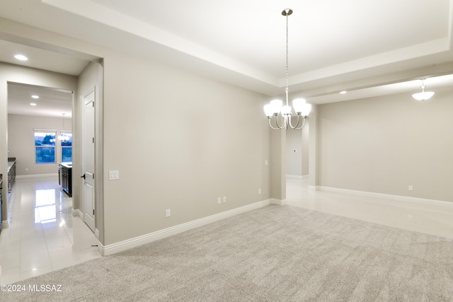 empty room featuring light carpet, light tile patterned floors, a raised ceiling, an inviting chandelier, and recessed lighting