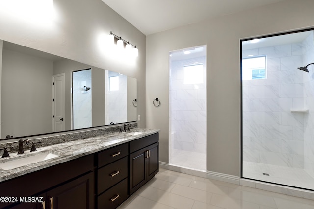 bathroom featuring vanity, tile patterned floors, and tiled shower