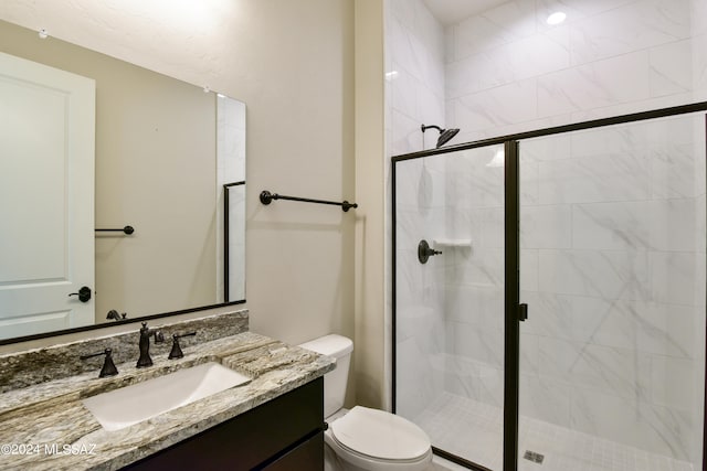 full bath featuring vanity, a shower stall, and toilet