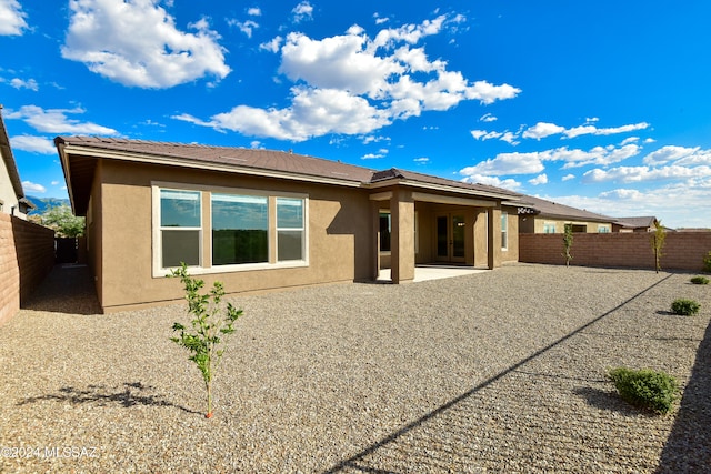 rear view of house with a patio area, a fenced backyard, and stucco siding