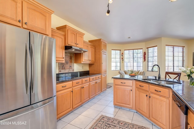 kitchen featuring light tile patterned floors, sink, tasteful backsplash, stainless steel appliances, and dark stone countertops