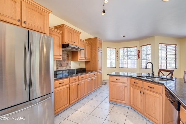 kitchen featuring light tile patterned floors, sink, stainless steel appliances, dark stone countertops, and decorative backsplash