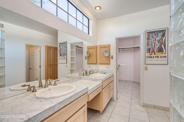 bathroom with a healthy amount of sunlight, tile patterned floors, and vanity