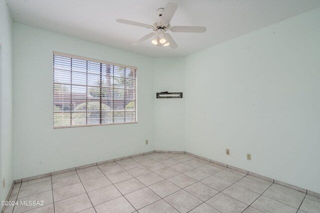 tiled spare room with ceiling fan