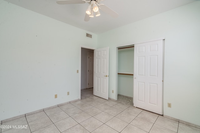 unfurnished bedroom with light tile patterned floors, ceiling fan, and a closet