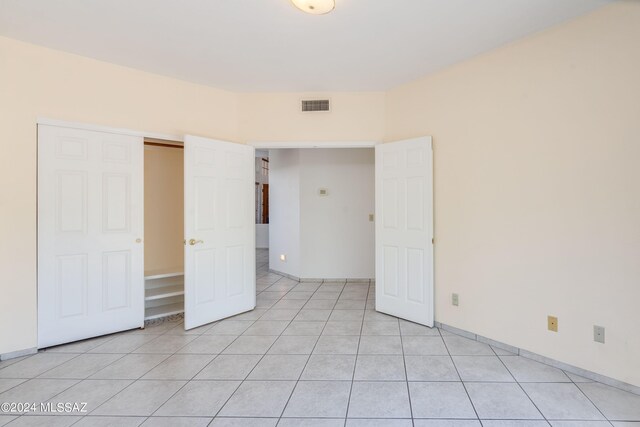 unfurnished bedroom with a closet and light tile patterned floors