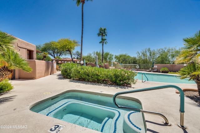 view of pool featuring a hot tub and a patio area